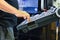 Worker, operator of the control panel of the program of operation of a high-precision CNC machining center, processing the manufac