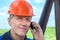 Worker in orange hardhat calling on the phone