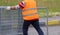 worker with orange high-visibility vest while moving the fences