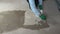 Worker with paintbrush priming concrete floor