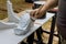 Worker is painting wooden corbels for a kitchen island with a paintbrush