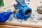 Worker paints a metal vise with blue paint. Stripping old paint