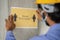 Worker pasting Keep 6 feet distance on wall at work place or construction site due to coronavirus or covid-19 pandemic -