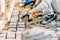 worker paving road with granite cobblestone using sand and rubber hammer