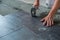 Worker placing ceramic floor tiles on adhesive surface