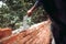 Worker placing and installing bricks on exterior wall on house construction. Worker using mortar, trowel and putty knife