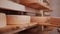 Worker placing maturing cheese wheels back on the shelf