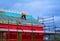 A worker placing wood on the sloped roof of a new house under construction.