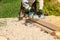 A worker planes a Board with a power tool, chips are flying