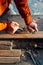 A worker planes a wooden bar with a plane