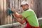 Worker polishing old wooden fence with power tool - a vibrating