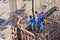 Worker pouring cement pouring into foundations and pillars formwork at building area in construction site