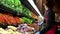 Worker pouring water on vegetables for sale in grocery store