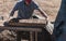 Worker pours the mixture of mud, sand and sawdust over molds for making bricks