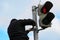 The worker prepares a fastening for the road sign pedestrian crossing on the traffic light column.