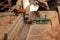 Worker preparing router table before shaving a piece of wood in carpentry workshop. Selective focus and shallow depth of field.