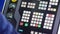 Worker presses buttons on machine control panel in workshop