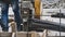 A worker presses a pedal of industrial cutting metal machine and rebar.