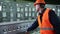 Worker pressing buttons on CNC machine control board in factory. Young engineer