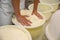 Worker pressing curd into mould at cheese factory