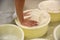 Worker pressing curd into mould at cheese factory