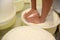 Worker pressing curd into mould at cheese factory