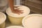 Worker pressing curd into mould at cheese factory, closeup