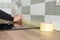 Worker protecting countertop in kitchen with masking tape before starting construction repairs with ceramic tiles