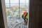 Worker in protective clothing and safety helmet installing plastic pipes using modern tools in flat of building under