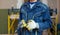 Worker with protective gloves is holdind a perforator with some drywall screws in apartment that is under construction