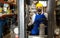 Worker in protective mask driving forklift in building materials store