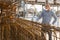 Worker in protective mask prepares metal rebar for loading onto truck