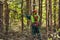 worker in a protective suit clears the forest from branches with a pole saw. clearing the forest with a chainsaw