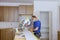 Worker protects himself from covid-19, man cut using circular saw rotating saw cutting wooden installation of in the kitchen of