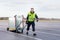 Worker Pulling Machine On Cart At Airport Runway