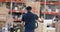 Worker pushing trolley with boxes in warehouse