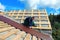 Worker puts the metal tiles on the roof