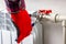 A worker in red gloves uses a wrench to twist pipes on a white radiator.