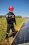 Worker in a red helmet makes a radio call in the solar power plant