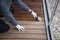 Worker refinishing wood, hand painting wooden deck floor with wood protection oil