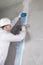 a worker reinforces the cracked wall with mesh