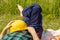 Worker relaxes lying on a meadow with a helmet and in working clothes, Concept, Work Life Balance, Balanced working and rest times