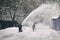 Worker removing snow from the moscow street using snow blower