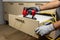 Worker repair wooden drawer of cabinet with pneumatic nail gun