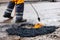 Worker repairing pothole with bitumen asphalt on the road