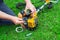 Worker repairs a carburetor in a trimmer or lawn mower that lies on the grass