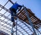 A worker rises to install a metal canopy