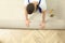 Worker rolling out new carpet flooring indoors, top view