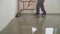 A worker rolls out the liquid floor with a trowel. Squeegee for distributing the mixture. The worker levels the liquid floor.
