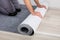 Worker`s Hands Unrolling Carpet On Floor